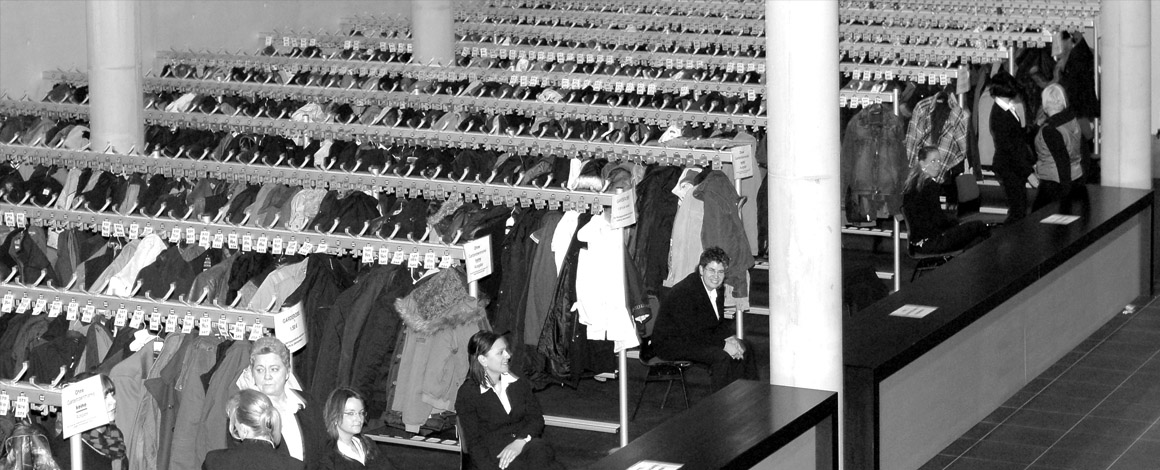 zwart-wit foto van een drukke vestiaire tijdens een beurs