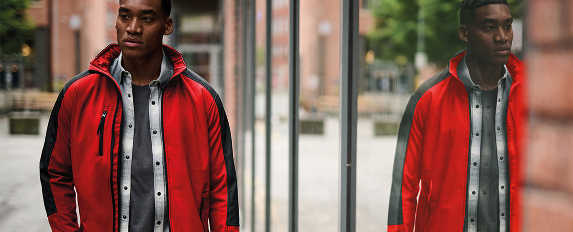 Man gekleed met een rode softshell wandelt door de straat