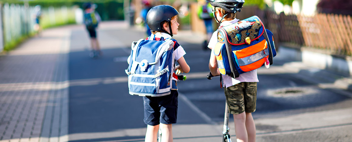 2 kids gaan naar school op hun step