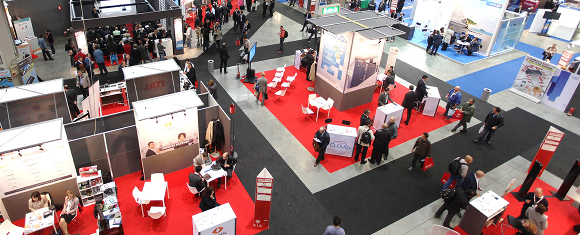 beursvloer van bovenaf bekeken met vele standen en bezoekers