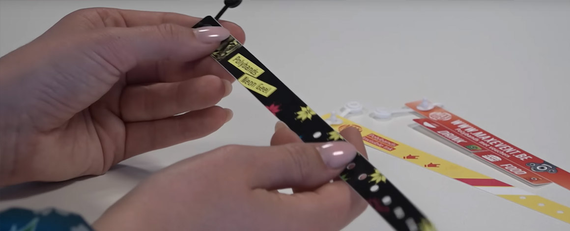 een vrouw heeft een polsbandje in haar handen van type polyband