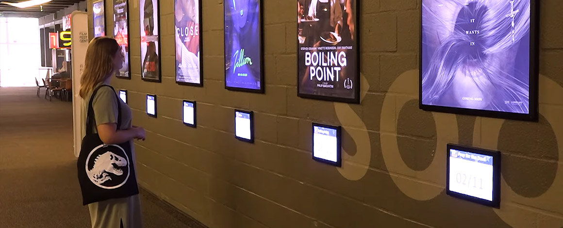dame met bedrukte totebag staat in Kinepolis Gent een film uit te kiezen uit het aanbod