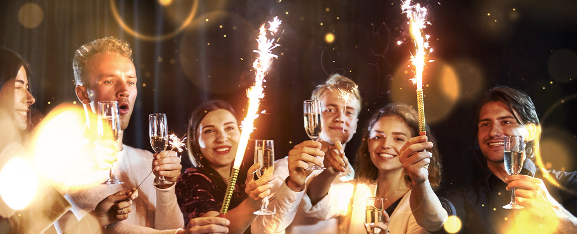 nieuwjaarsdrink onder collega's met glazen champagne en vuurwerk