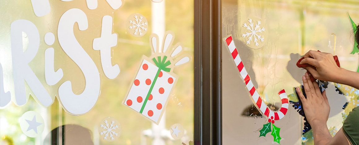 raamstickers in kerst thema die worden aangebracht op een vitrine voor tijdelijke reclame of sfeer