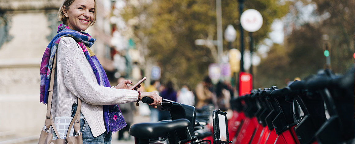 dame bij een georganiseerde fietstenstalling met fiets in de hand