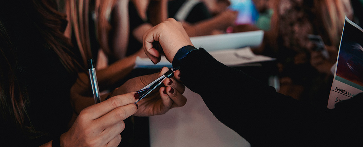 close up van een event polsbandjes met plastic schuifsluiting dat door een vrouw bij een andere vrouw wordt omgedaan