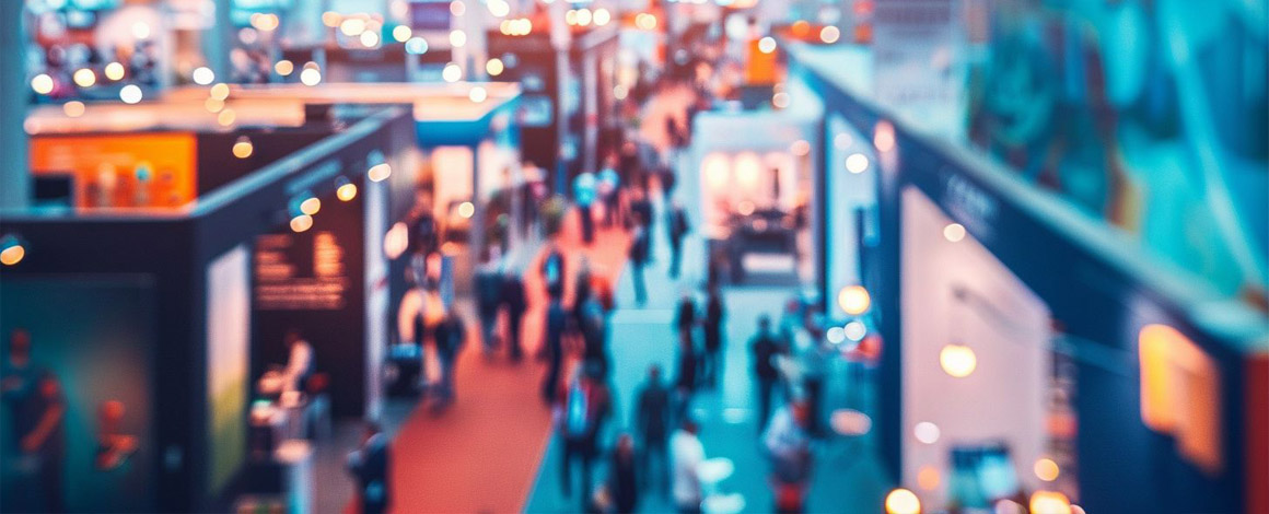 onscherpe foto van een beursvloer met beursstanden en bezoekers