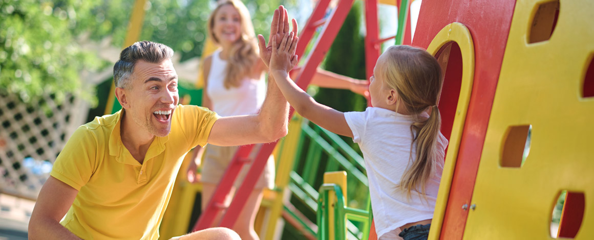 gezin in een speeltuin op een zonnige dag