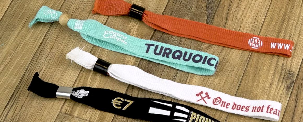 4 bamboe stoffen festivalbandjes op een houten tafel in verschillende kleuren