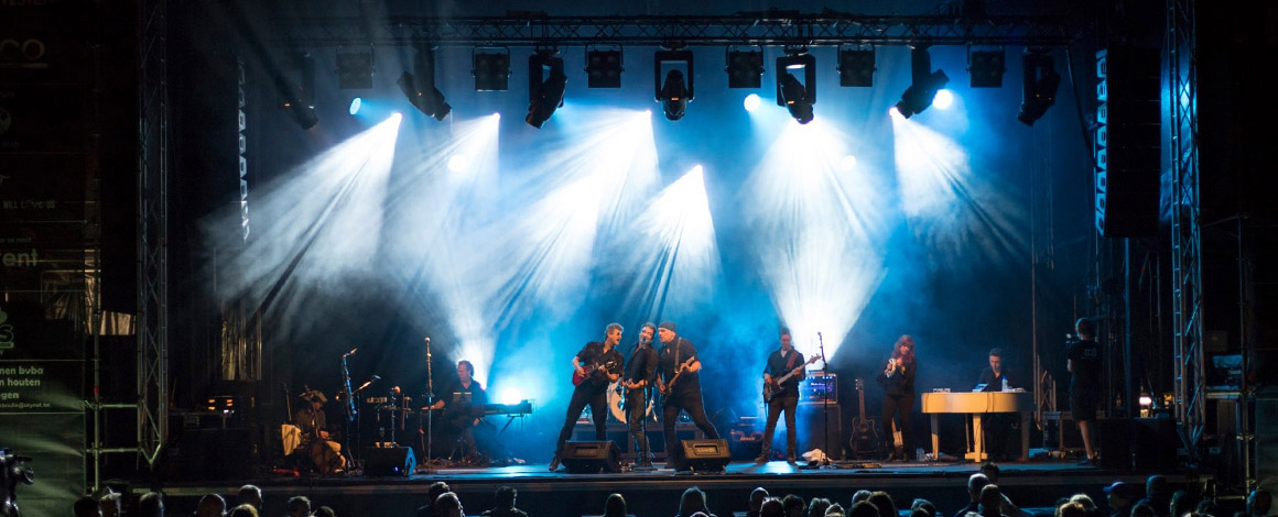 een band treedt 's avonds op op een openlucht podium
