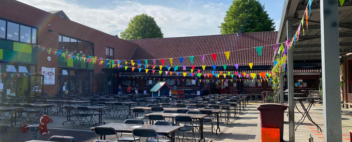 Schoolfeest met drukte op een versierde speelplaats