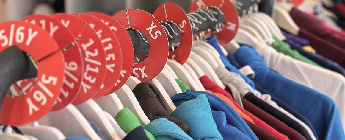 close-up van sweaters en hoodies in verschillende kleuren op een kledingrek